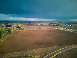 A dark thundercloud is moving over a rural field. A cloud with a clearly visible rain line. Aerial...