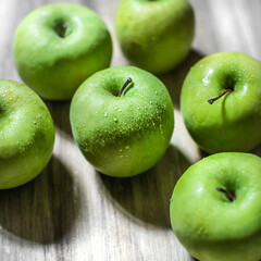 Overhead of green apples on wood background