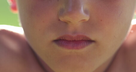Upset child boy changing emotion becoming serious. Macro close-up kid lips