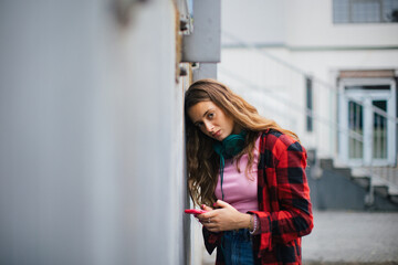 Gen Z girl outdoors in the city, feeling sad and anxious.