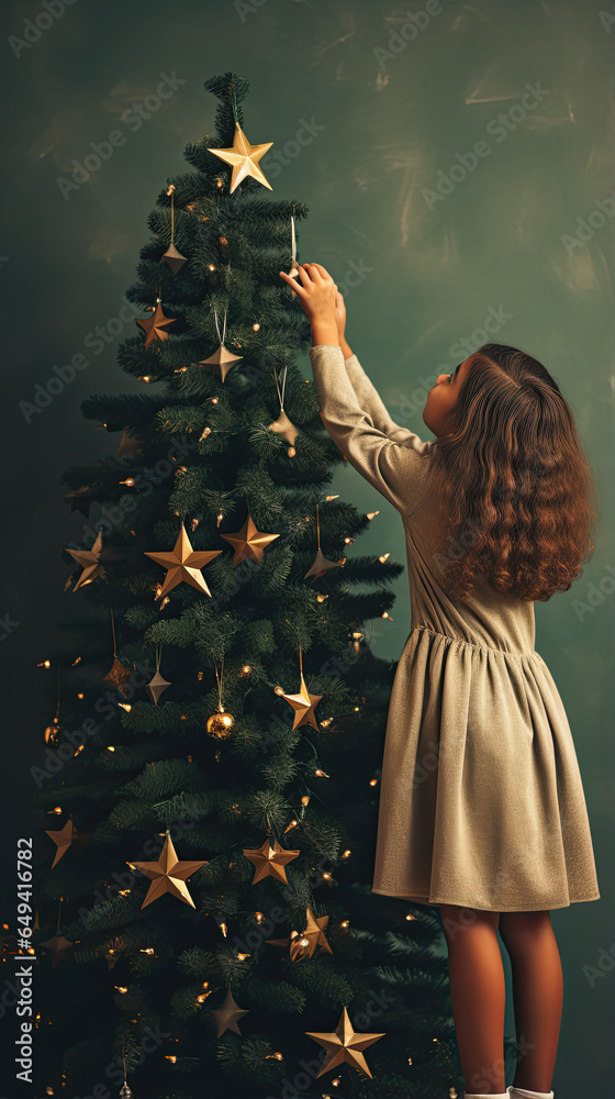 Wall mural little girl decorating christmas tree with ornaments. winter holidays and people concept