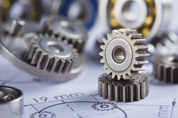 Close up metal gears and bearings. Background with drawings of the mechanism. Industrial mechanism.