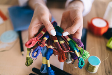Hands of dressmaker showing colorful threads
