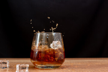Splashes of ice in a whiskey glass