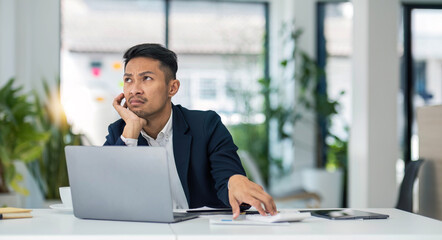 Young unhappy man office worker feeling bored at work, looking at laptop with demotivated face...