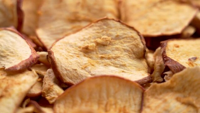Sliced thin crispy apple chips close up. Rotation