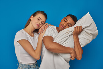 pleased interracial couple sleeping together on pillow, african american man and caucasian woman