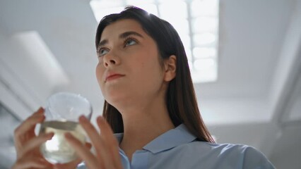 Closeup girl drinking water at lamp light. Beautiful office manager rest break