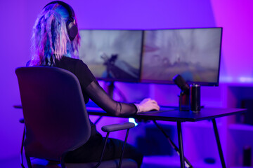 E-sport gamer girl plays first-person shooter online video game on PC