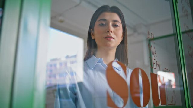 Beautiful sales woman look throught glass window closeup. Small business owner
