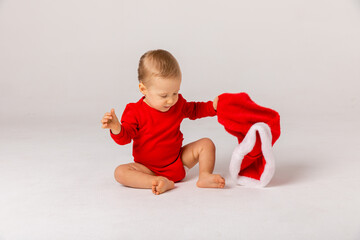 Adorable smiling child boy wearing red Christmas cap on white background. Children's emotions. Christmas and New year. The concept of an advertising banner.