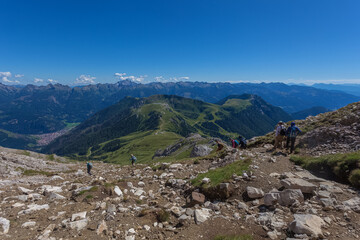 Unrecognizable trekkers go down the path from Torre di Pisa Hut. Latemar Massif, UNESCO world heritage site, Trentino-Alto Adige, Italy, Europe