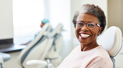 Portrait of a happy dark-skinned adult woman in a dental office. African American woman undergoes a consultation with a dentist in a specialized clinic. Dental health concept. - obrazy, fototapety, plakaty