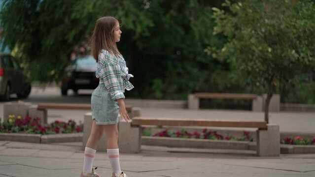 Child girl doing handspring on urban street.