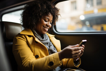 A smiling middle-aged African American businesswoman using a smartphone in a taxi cab
