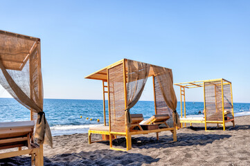 Fira, Greece - July 20, 2023: Palapas and beach chairs on the island of Santorini in Greece
