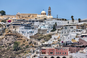 Fira, Greece - July 20, 2023: Cliffside buildings and walkways in the town of Fira on the island of...
