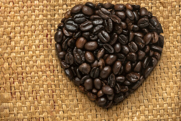 Heart-shaped coffee beans on a fique sack background