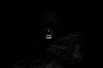 mysterious woman painted and dressed in black and gold leaf lips