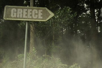 old signboard with text greece near the green sinister forest
