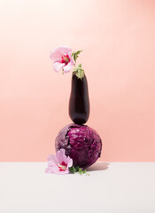 Still life with eggplant, purple cabbage and flowers.