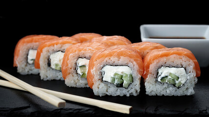 Delicious sushi roll with salmon, cream cheese, and cucumber