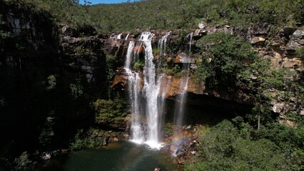 Obraz premium aerial view of the Cachoeira do Cordovil waterfall in Chapada dos Veadeiros Goiás Brazil green water, sunny day, waterfall, rocks and vegetation of the cerrado