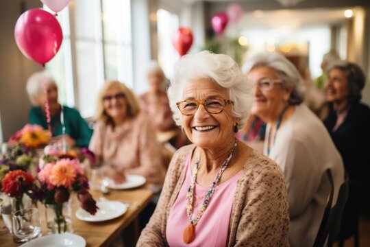 Happy senior woman celebrating her birthday in a nursing home with her female friends