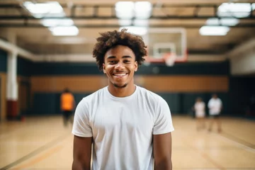 Fotobehang Smiling portrait of a happy young african american basketball player in a indoor basketball gym © Geber86