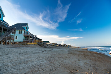 Beach and houses on stilts under a blue sky on the shores of the Atlantic Ocean