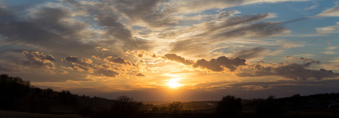 Rural landscape at sunset through the rain. Panorama.