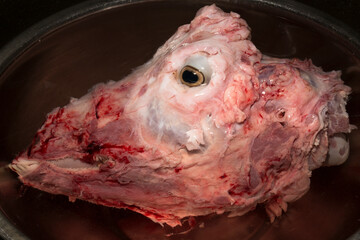 Sheep meat in water. The head of the animal without the skin. The eye of a slaughtered animal. Price for meat-eating.