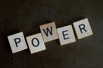 Macro Image of the Word Power in Wooden Blocks on Metal Background