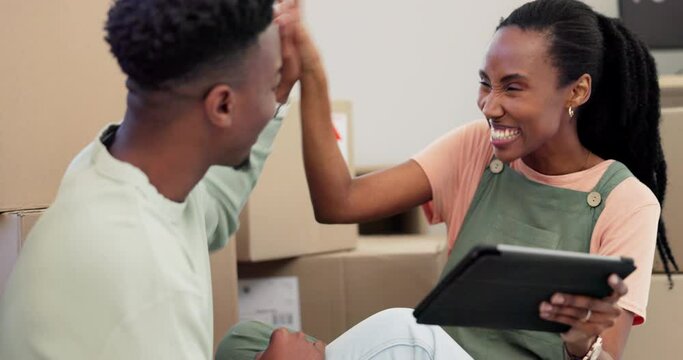 Tablet, High Five And A Black Couple Laughing While Moving House Together With Boxes In Their Apartment. Real Estate, Funny And Renovation With Young People In Their New Home For Investment Success