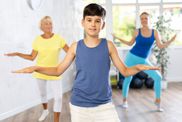 Fototapeta premium Grandmother, mother and teen son learn to dance sports jazz modern in gym. Joint pastime, active lifestyle concept