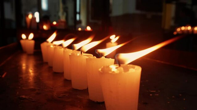 Velas candelas veladoras de cera parafina encendidas en iglesia templo parroquia cat&oacute;lica tradici&oacute;n de fe y esperanza en oscuridad contemplaci&oacute;n y oraci&oacute;n