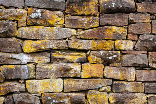 Empty Old Brick Wall Texture.Close-up and high resolution photo from across a wall covered with moss and covered with natural stones. Text space is available. Background and print images with wall.