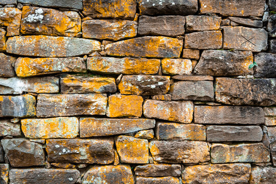 Empty Old Brick Wall Texture.Close-up and high resolution photo from across a wall covered with moss and covered with natural stones. Text space is available. Background and print images with wall.