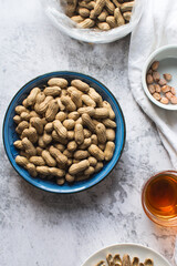 shelled groundnut in a plate, flatlay of shelled peanut in a blue plate on a marble countertop, nigerian roasted groundnut in a bowl