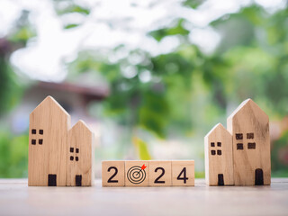 Wooden block with 2024 and goal business icon with miniature house. Property investment, House mortgage, Real estste, Family concept