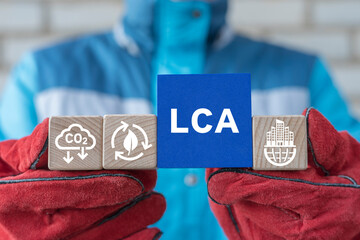 Engineer or worker holding colorful blocks with icons and abbreviation: LCA. Concept of LCA Life...