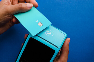 Closeup of hands holding a modern credit card payment device, Contactless technology facilitating...