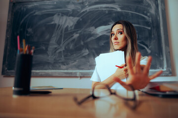 Professor Holding Papers Making Stop Hand Gesture. Stressed teacher having to grade assignments in...