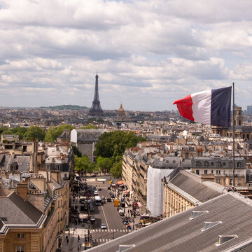 France, Paris, French flag on building roof, Eiffel tower in background 