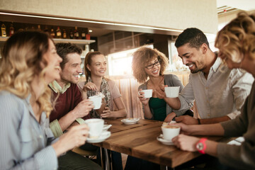 Young and diverse group of people having coffee together at a cafe in the city