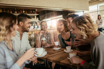 Young and diverse group of people having coffee together at a cafe in the city