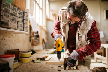 Middle aged male Caucasian carpenter working in a wood shop