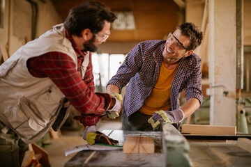 Two male carpenters working in a wood shop