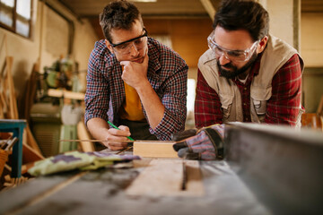Two male carpenters working in a wood shop