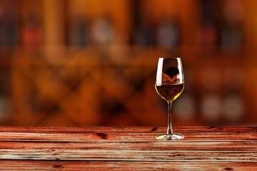 Empty table top with wine bottles in wooden rack in wine cellar.background for blurred